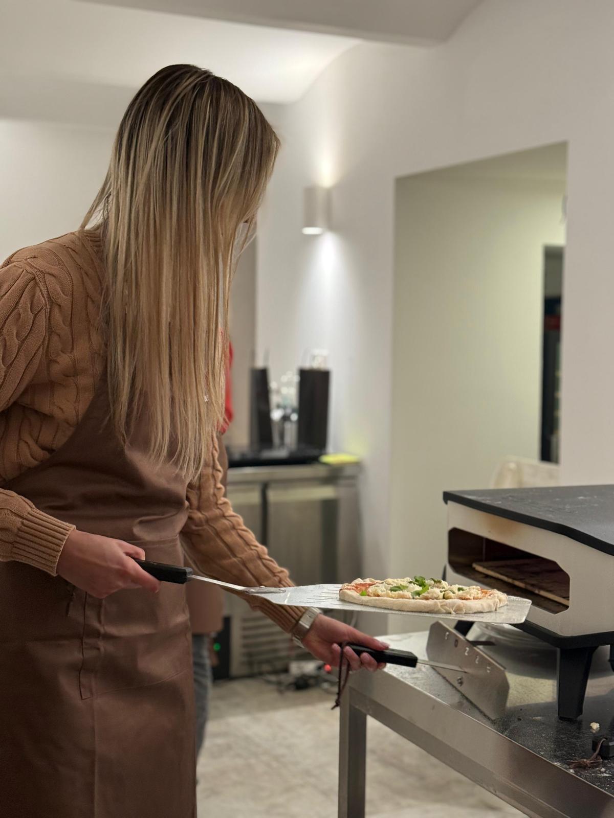 Polaznica stavlja pizzu u peć